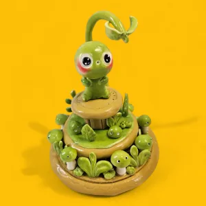 Figurine mignonne en argile polymère avec un décor végétal, parfaite pour un cadeau adorable et original pour une baby-shower. Représentation d'un gribouillis après la transformation en figurine originale et personnalisée.
